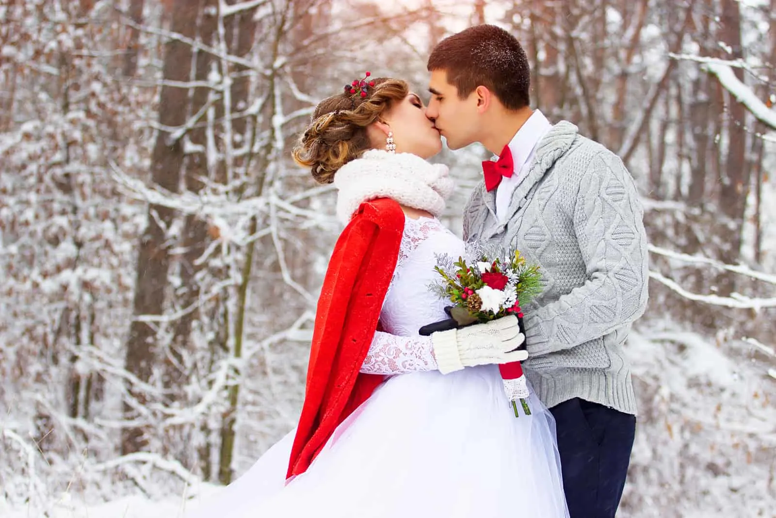 Winterhochzeit, Jungvermählten küssen sich im Wald