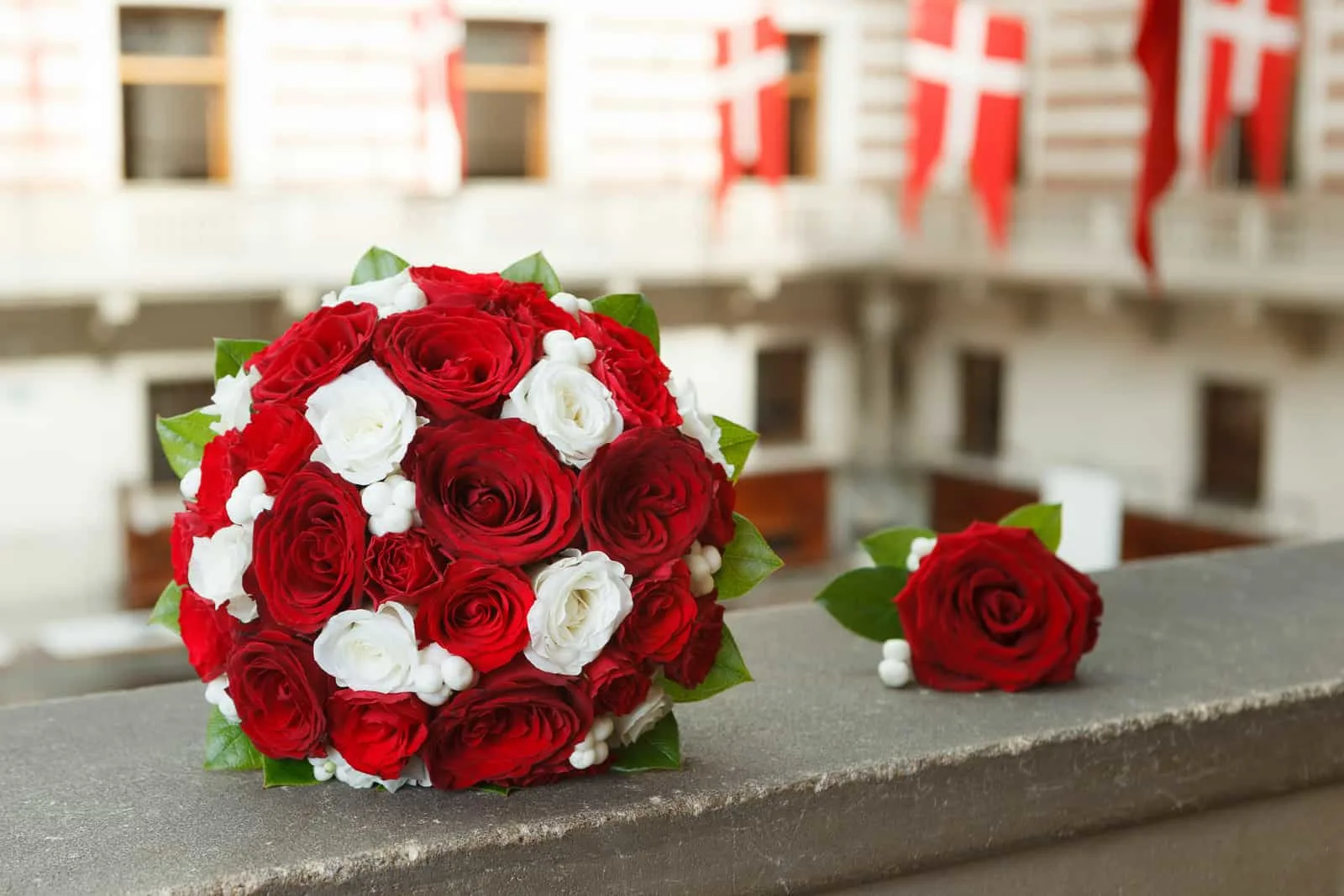 ein Strauß roter und weißer Rosen im Hintergrund der dänischen Flagge