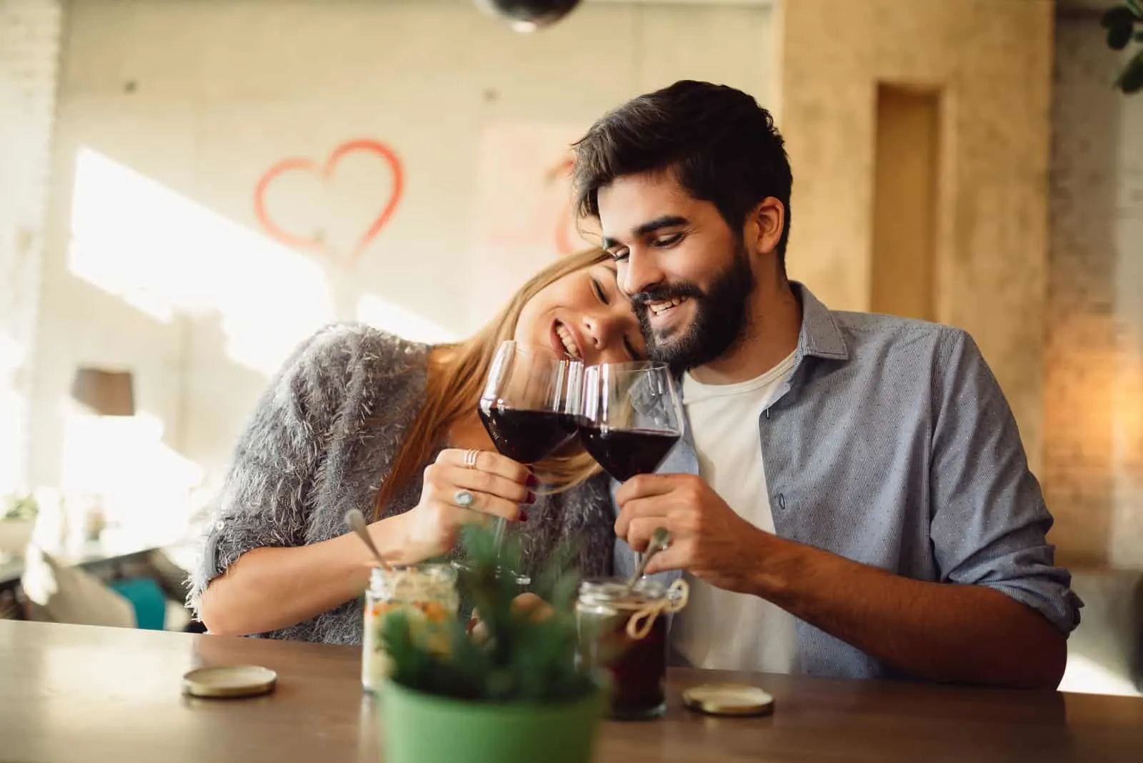 glückliches Paar an der Bar trinkt Wein