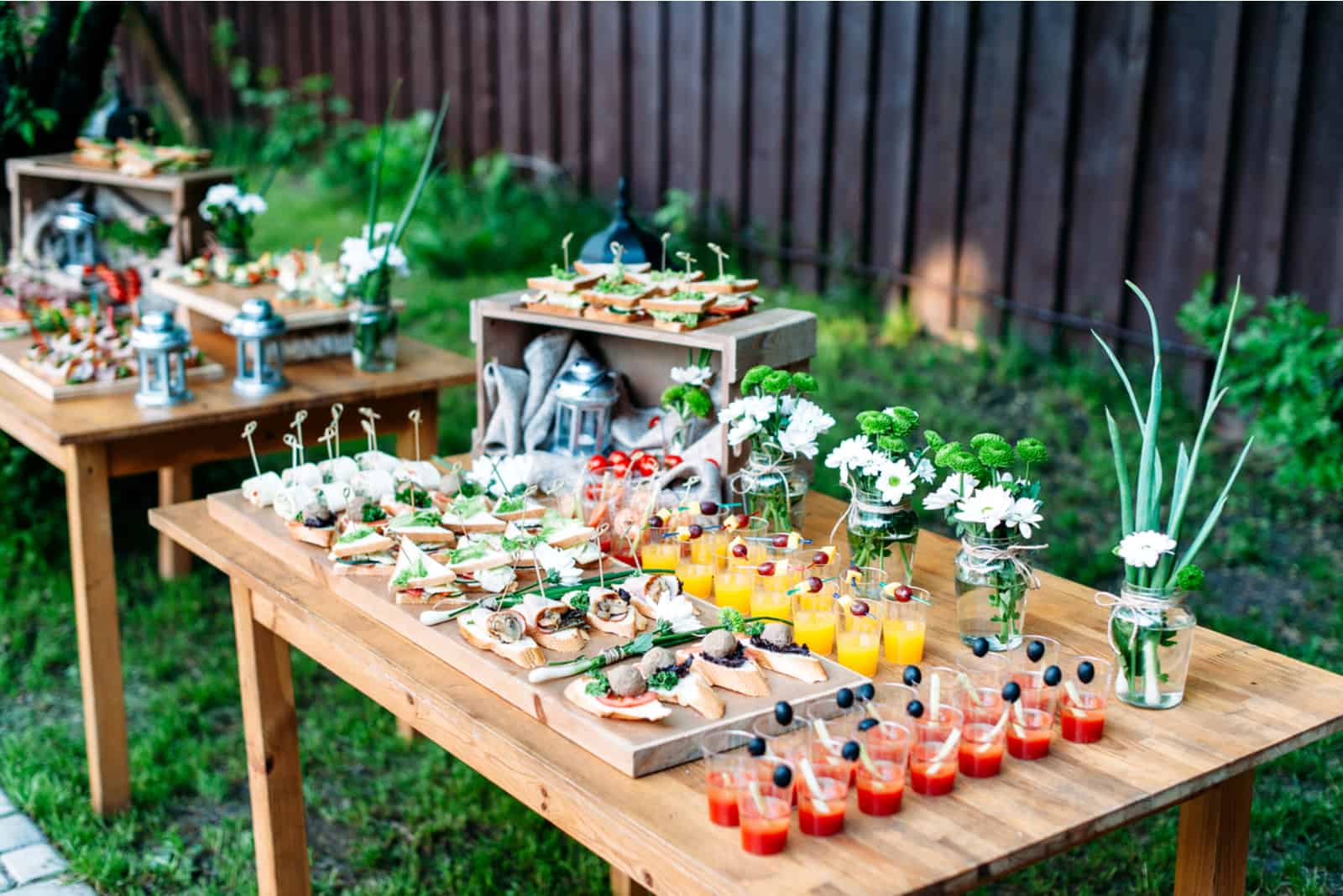 schön dekorierte Speisen und Getränke auf den Tischen im Garten