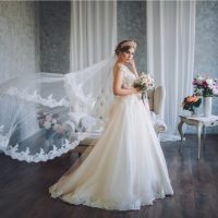 Schöne Braut im Hochzeitskleid mit Spitze