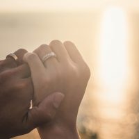 Hochzeitspaar Händchenhalten auf Meer Sonnenuntergang Hintergrund