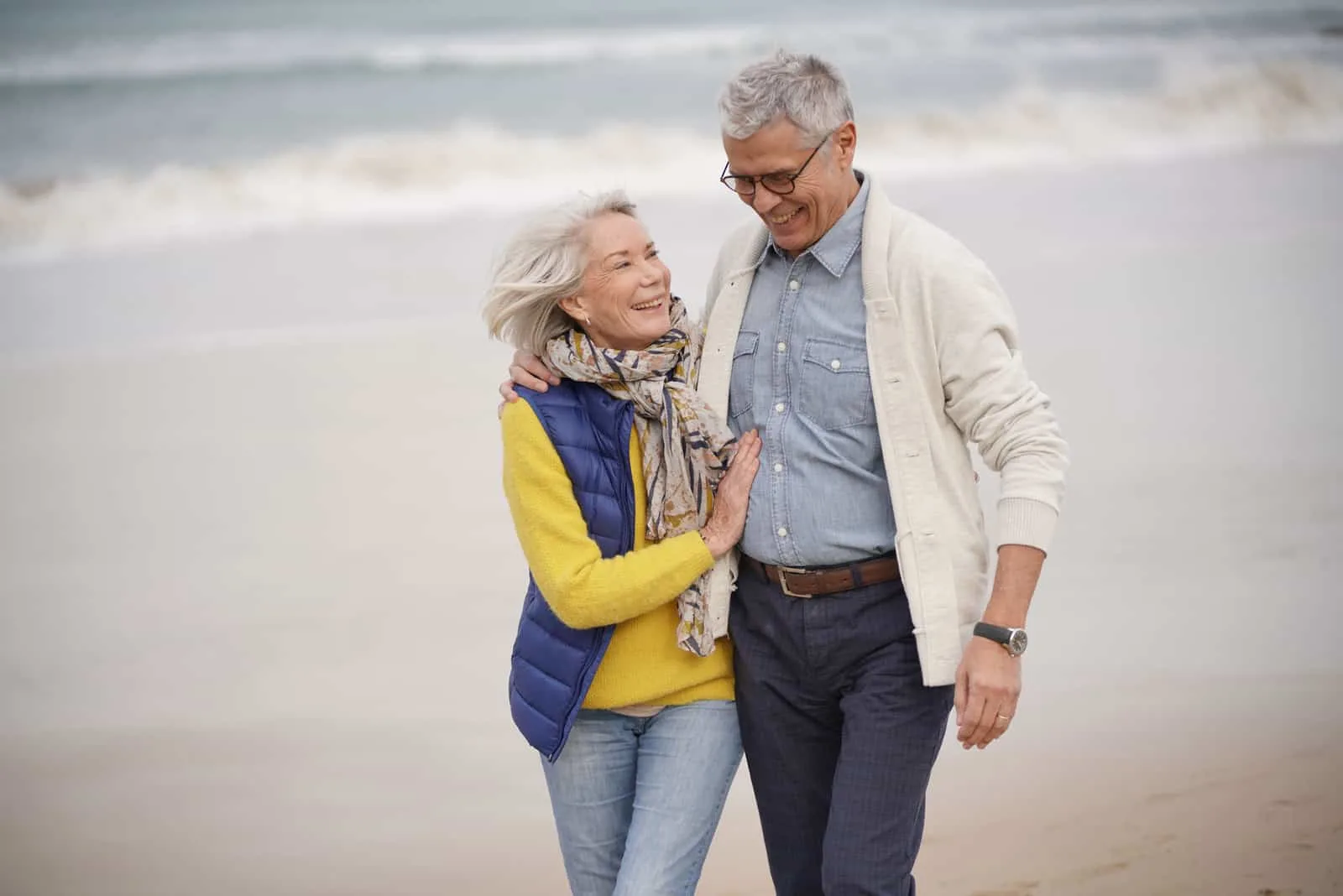 Ein älteres glückliches Paar geht am Strand entlang