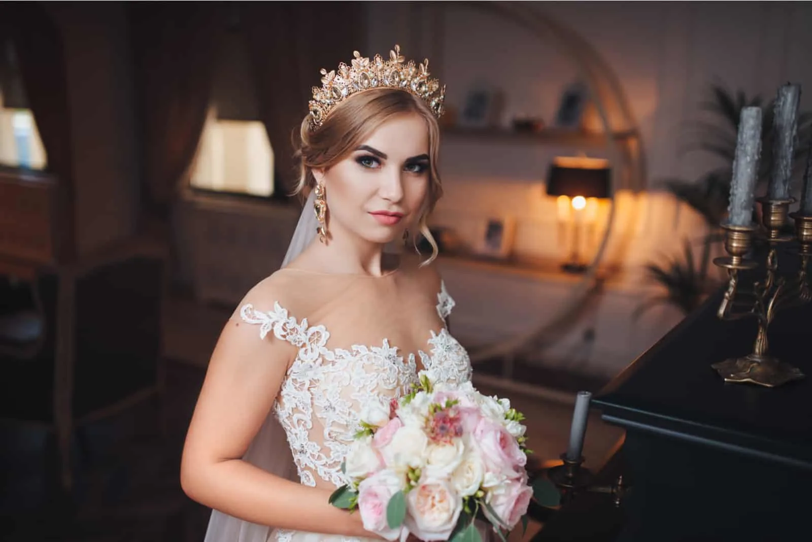 Eine blonde Braut mit einer Krone oder einem Diadem auf dem Kopf schaut in die Kamera