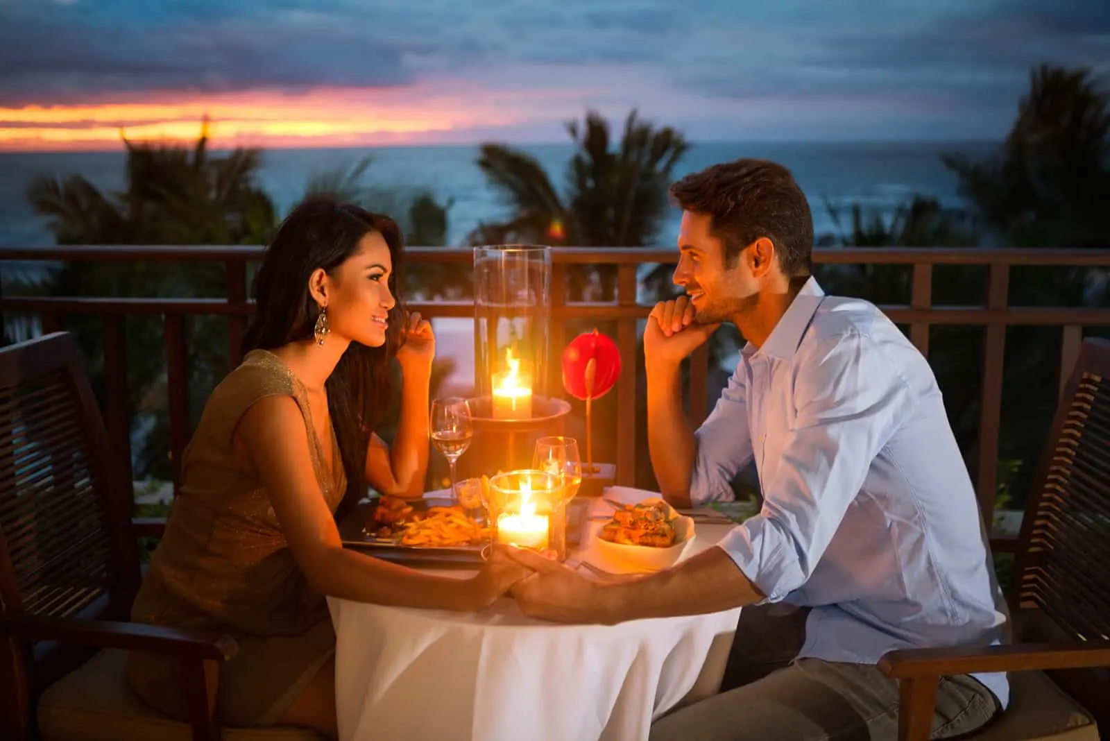 Romantisches Paar essen mit Sonnenuntergang und Kerzenlicht zu Abend