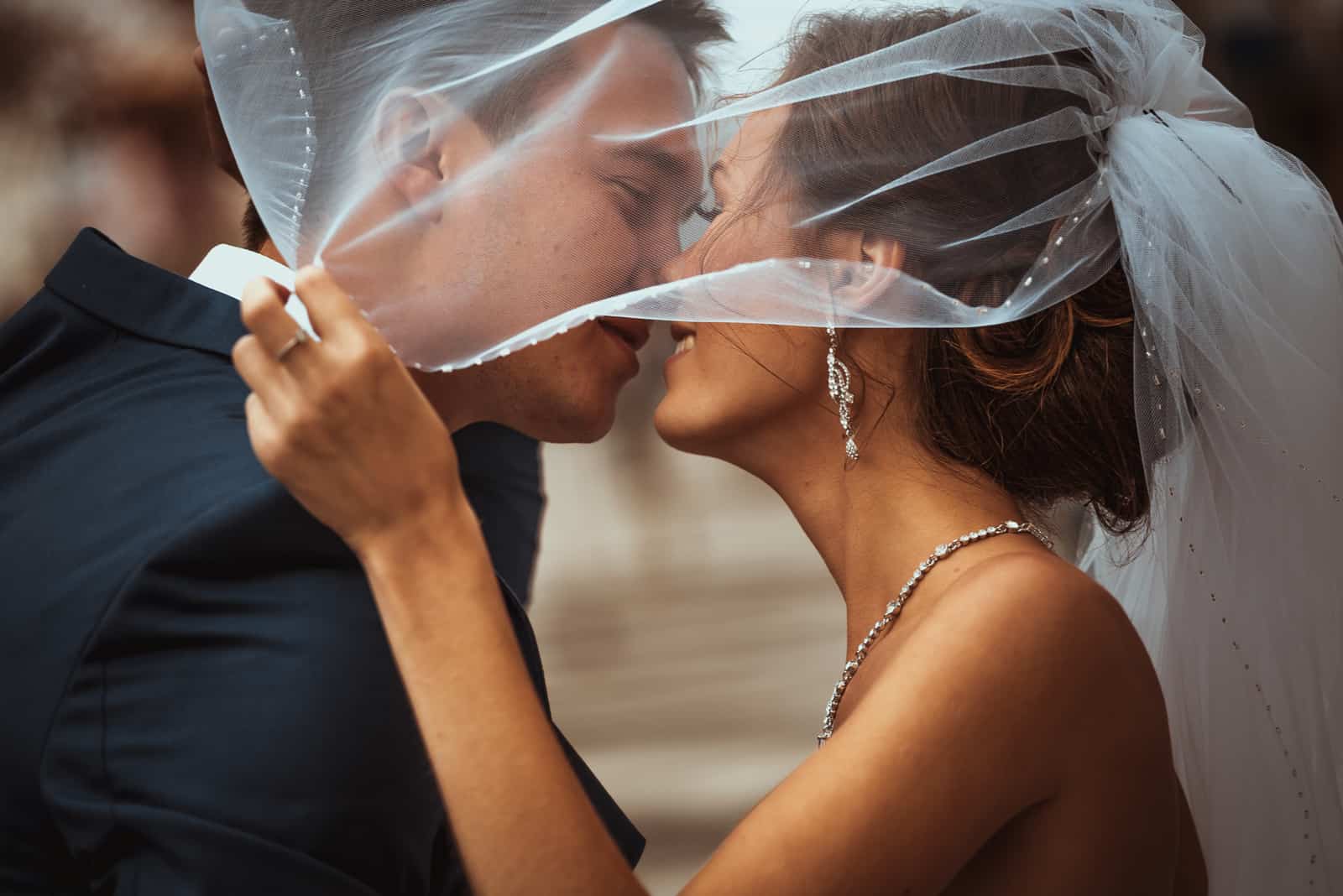 Braut und Bräutigam küssen sich vor dem Hintergrund der Stadt