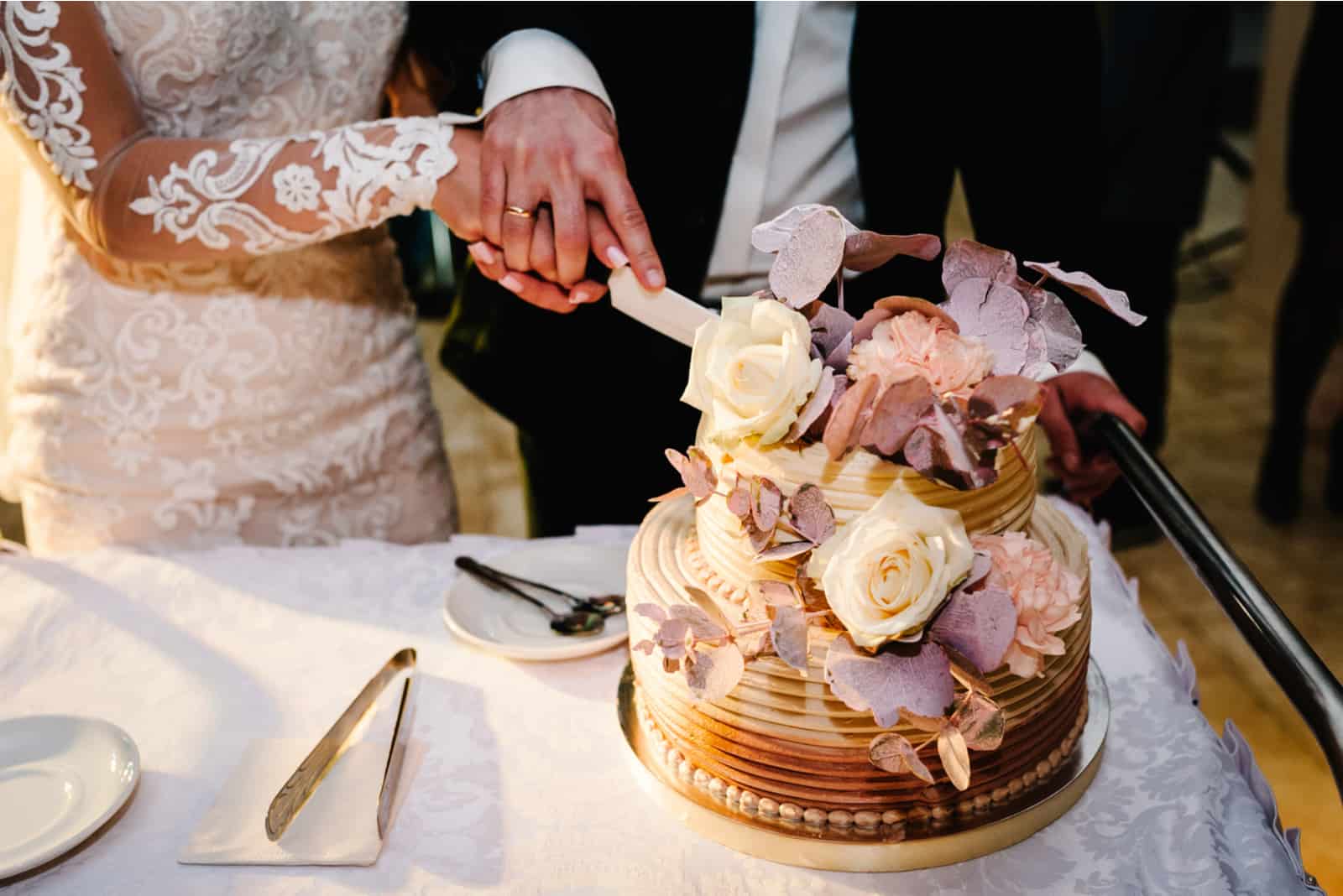 Braut und Bräutigam schneiden ihre rustikale Hochzeitstorte an