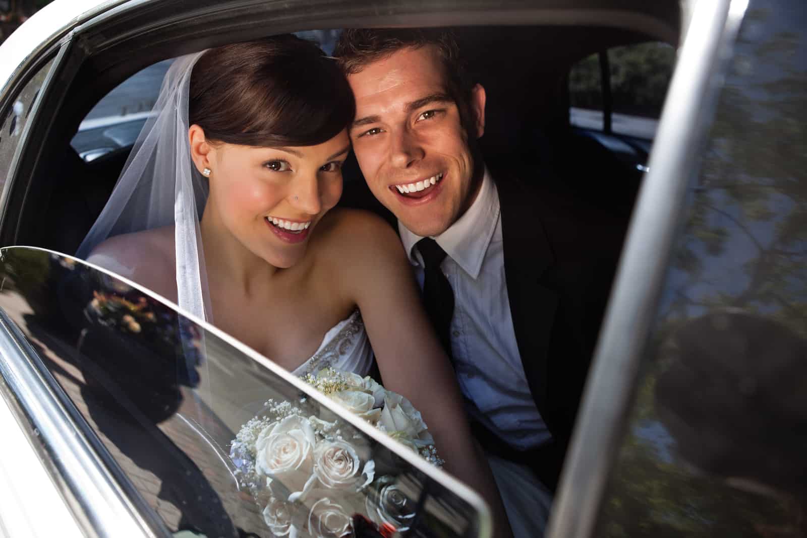 glückliches frisch verheiratetes Paar im Auto