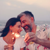 Paar feiert mit Wunderkerzen am Strand