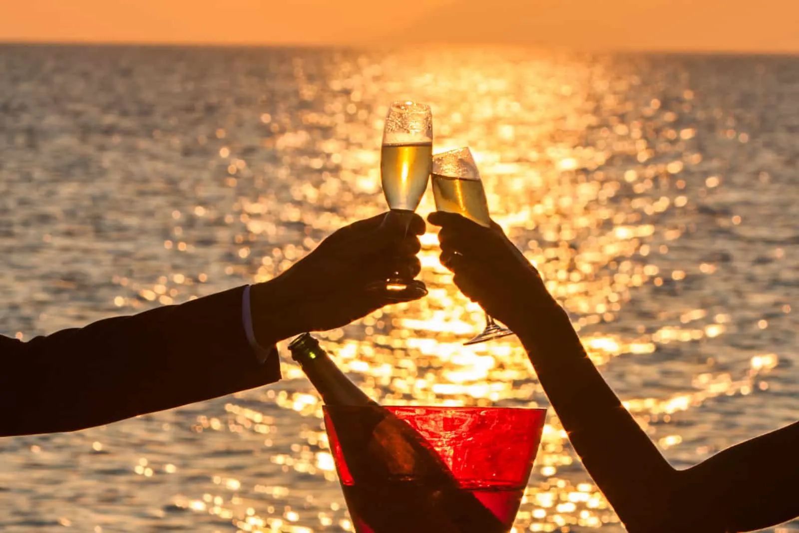Paar bei Sonnenuntergang am Strand mit Champagner
