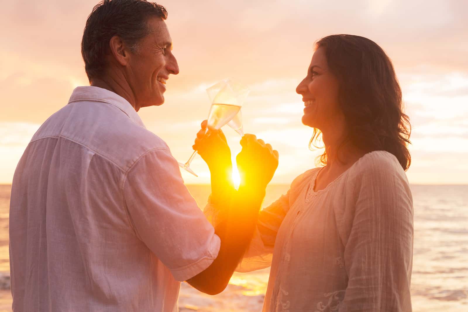 Romantisches Paar genießt ein Glas Champagner bei Sonnenuntergang