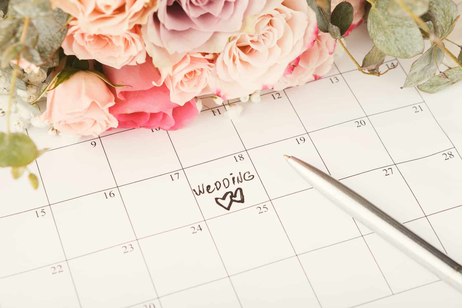 Worthochzeit und zwei Herzen auf Kalender mit süßem Rosenstrauß