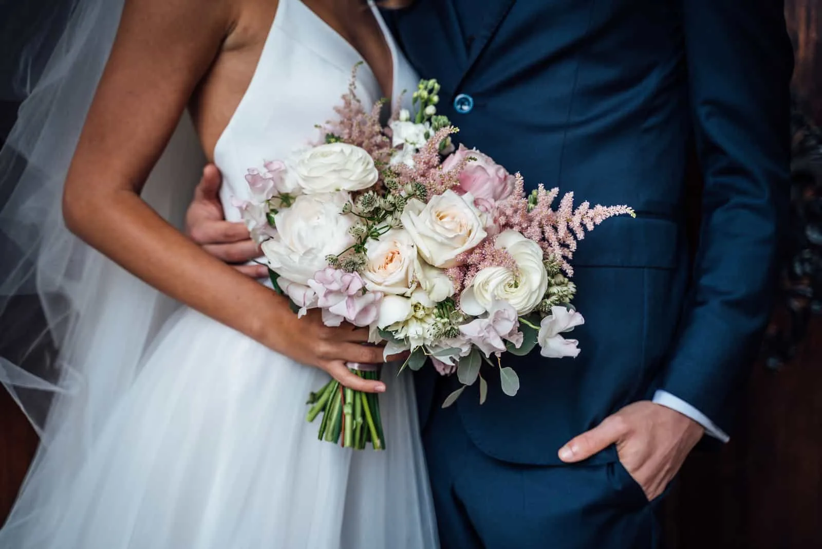 Braut mit Hochzeitsstrauß aus weißen und rosa Rosen
