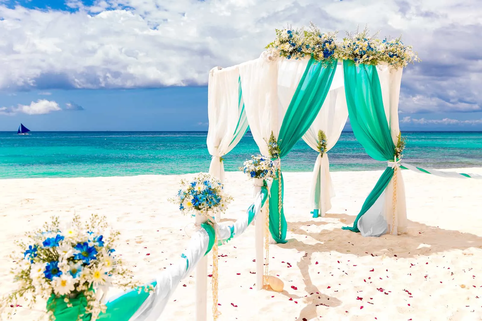 Hochzeitsbogen verziert mit Blumen am tropischen Sandstrand