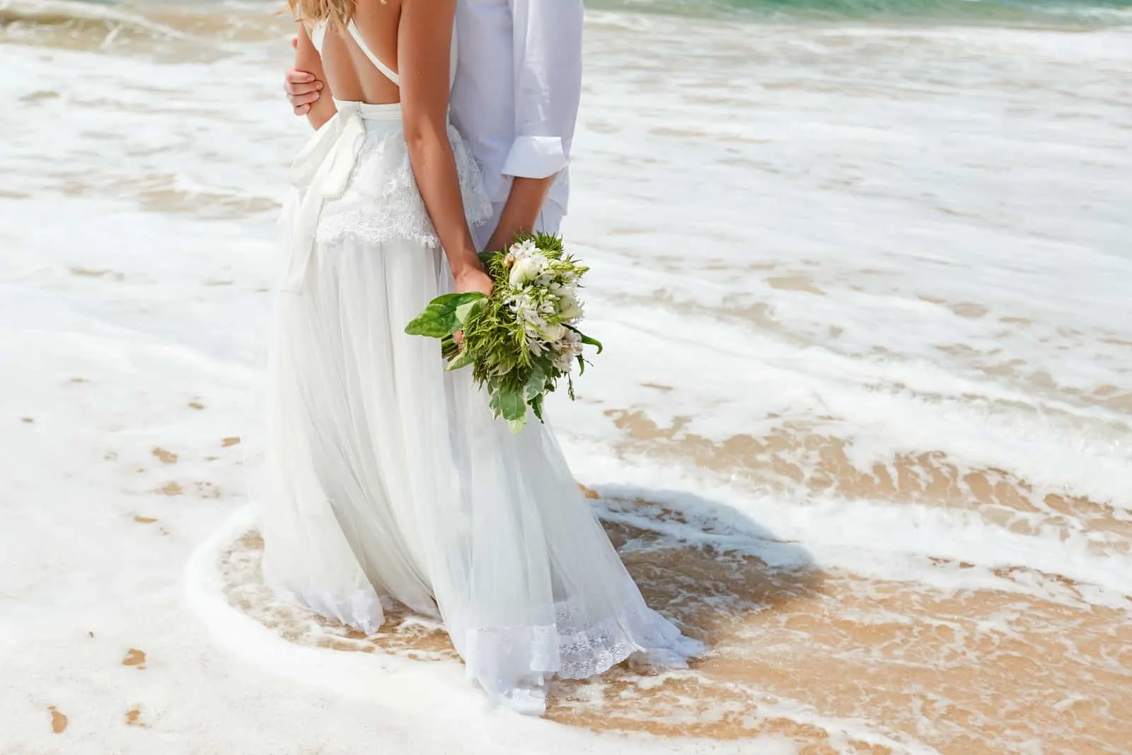 das Brautpaar steht am Strand