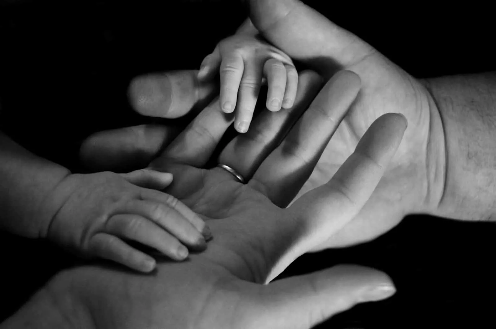 Schwarz-Weiß-Foto von Familie, die Händchen hält