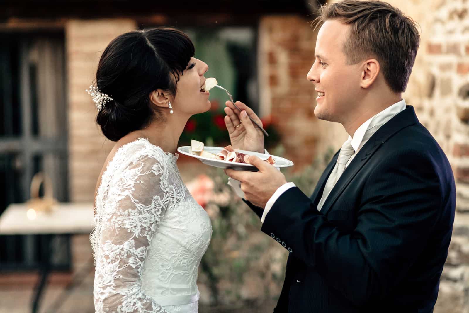 Bräutigam füttert die Braut mit Torte