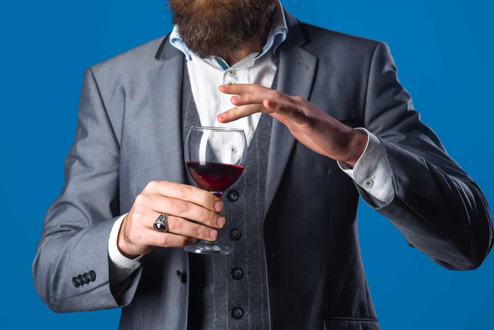 Mann im Anzug hält ein Glas
