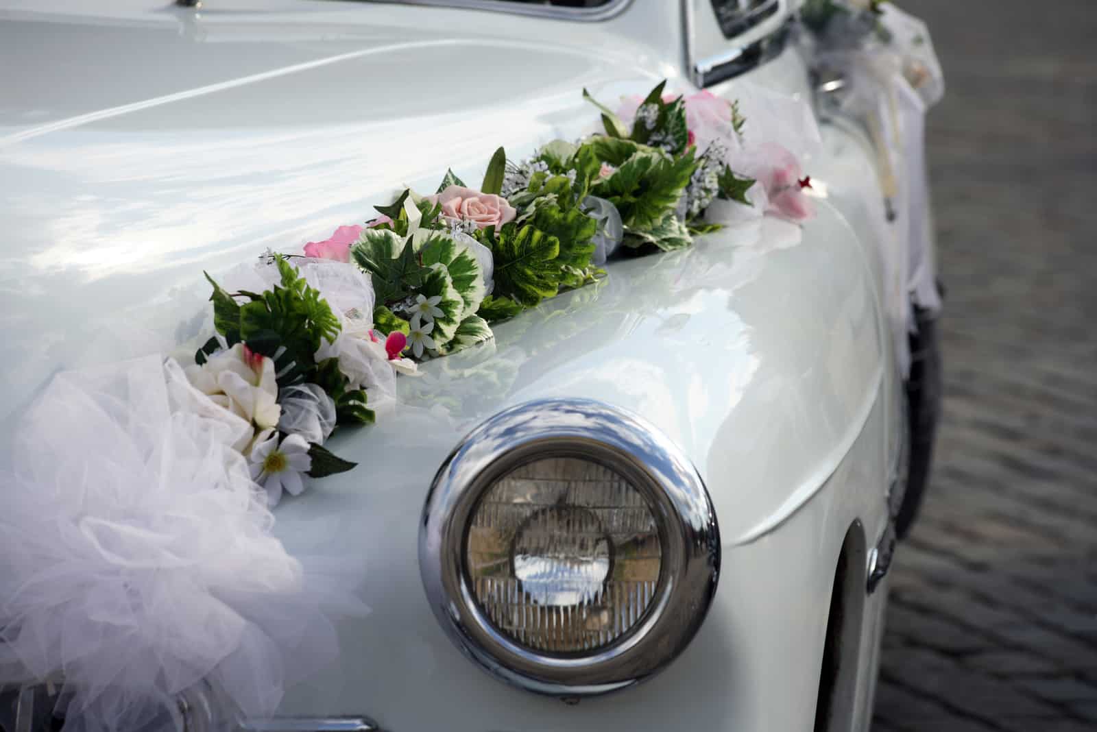 weißes Auto mit Hochzeitsdekoration