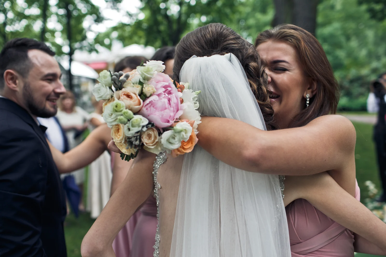 emotionale Trauzeugin umarmt die Braut