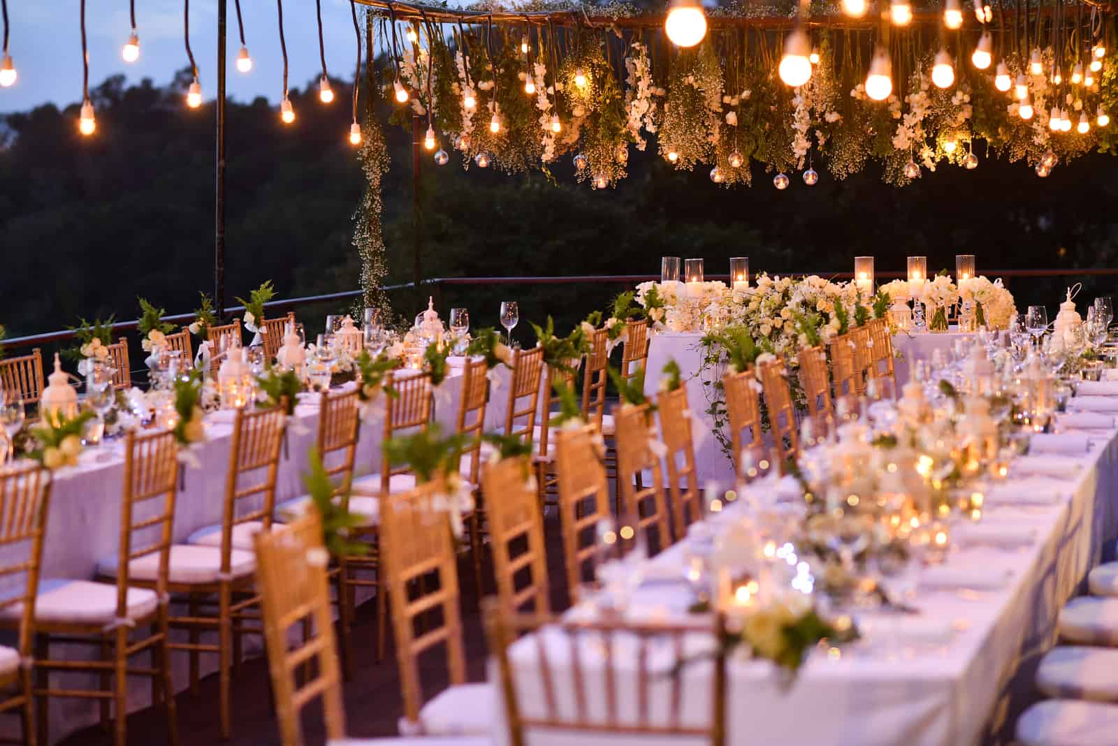 weiße Hochzeitstische mit goldenen Stühlen