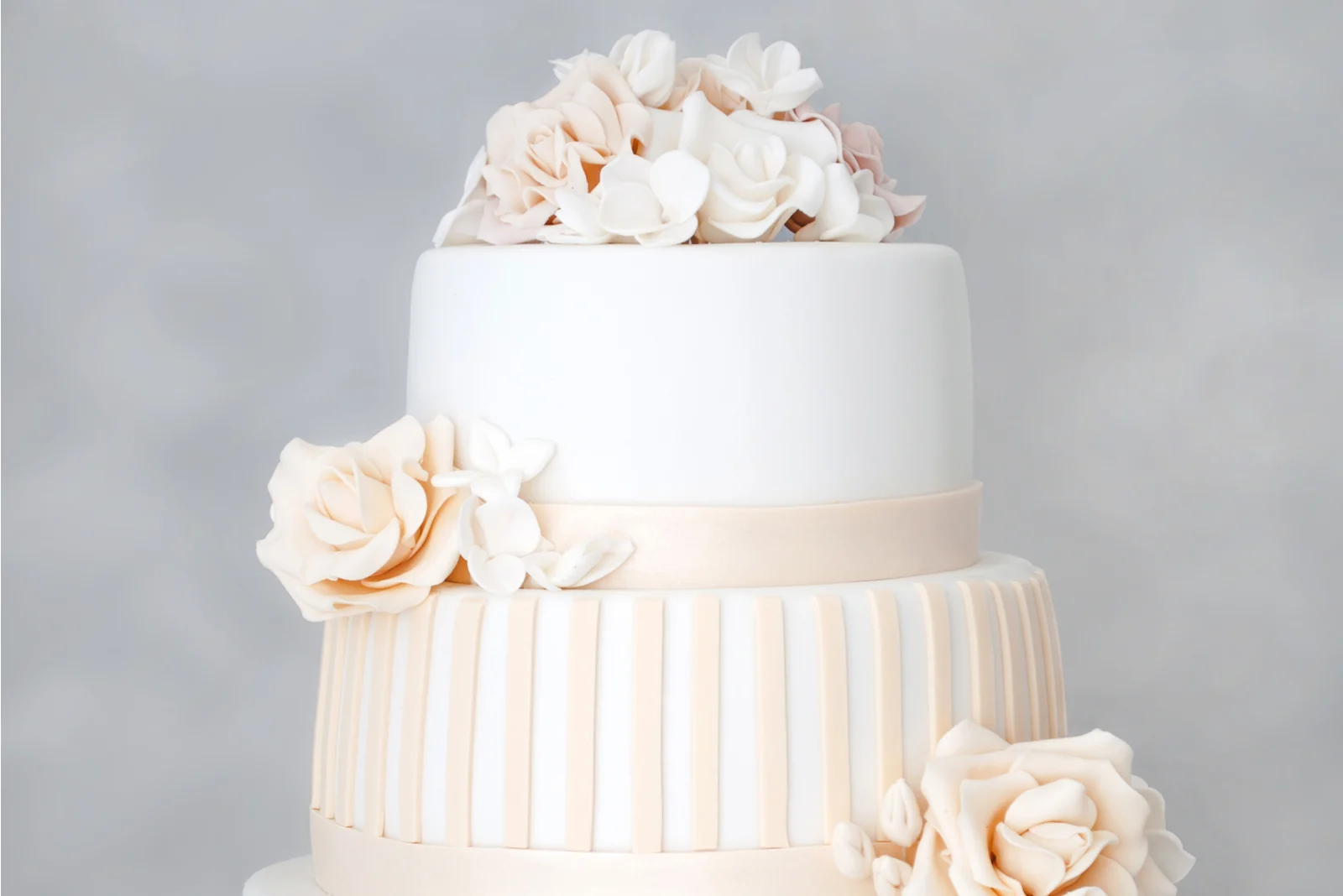 weißer Kuchen mit rosa Blumen mit grauem Hintergrund
